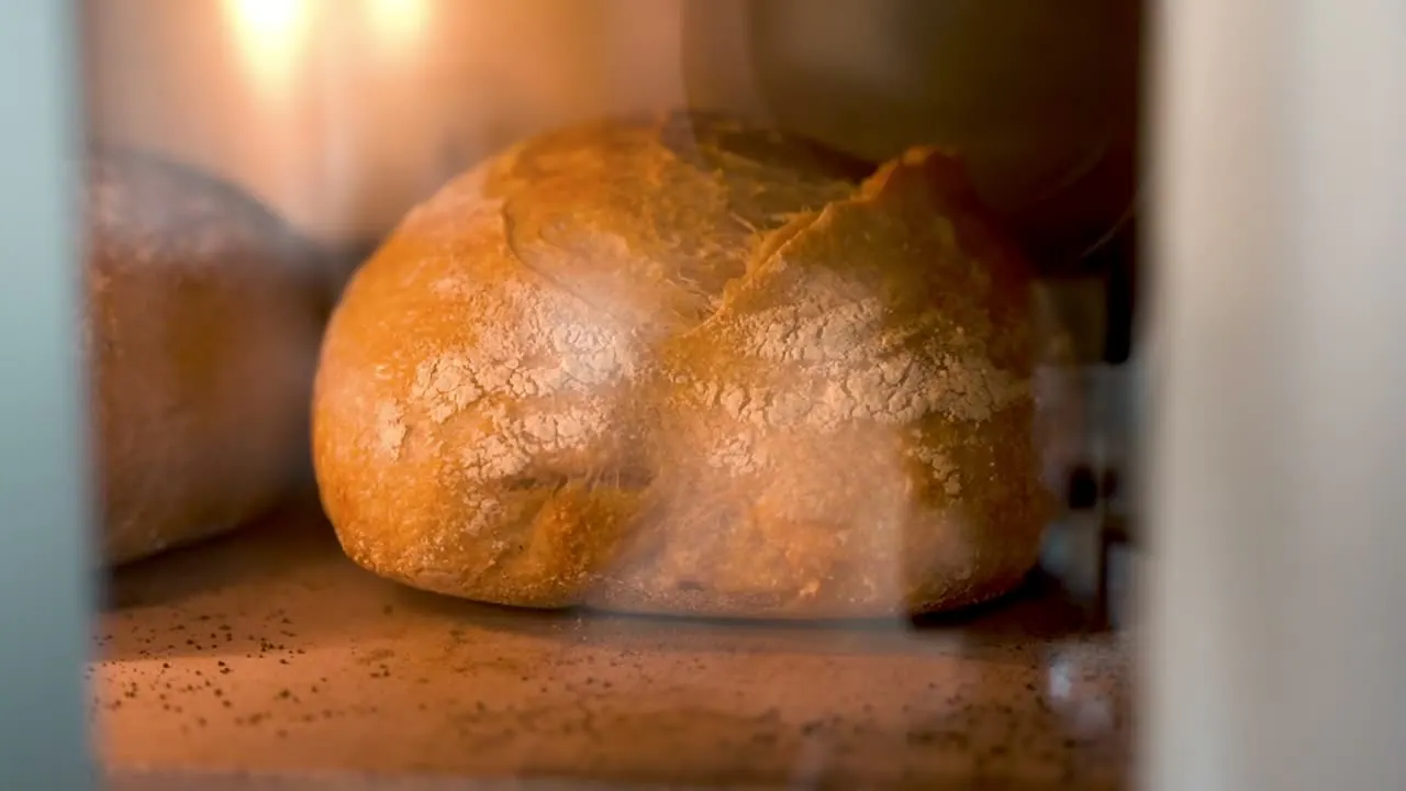 Focaccia baking inside the oven, lit from within.
