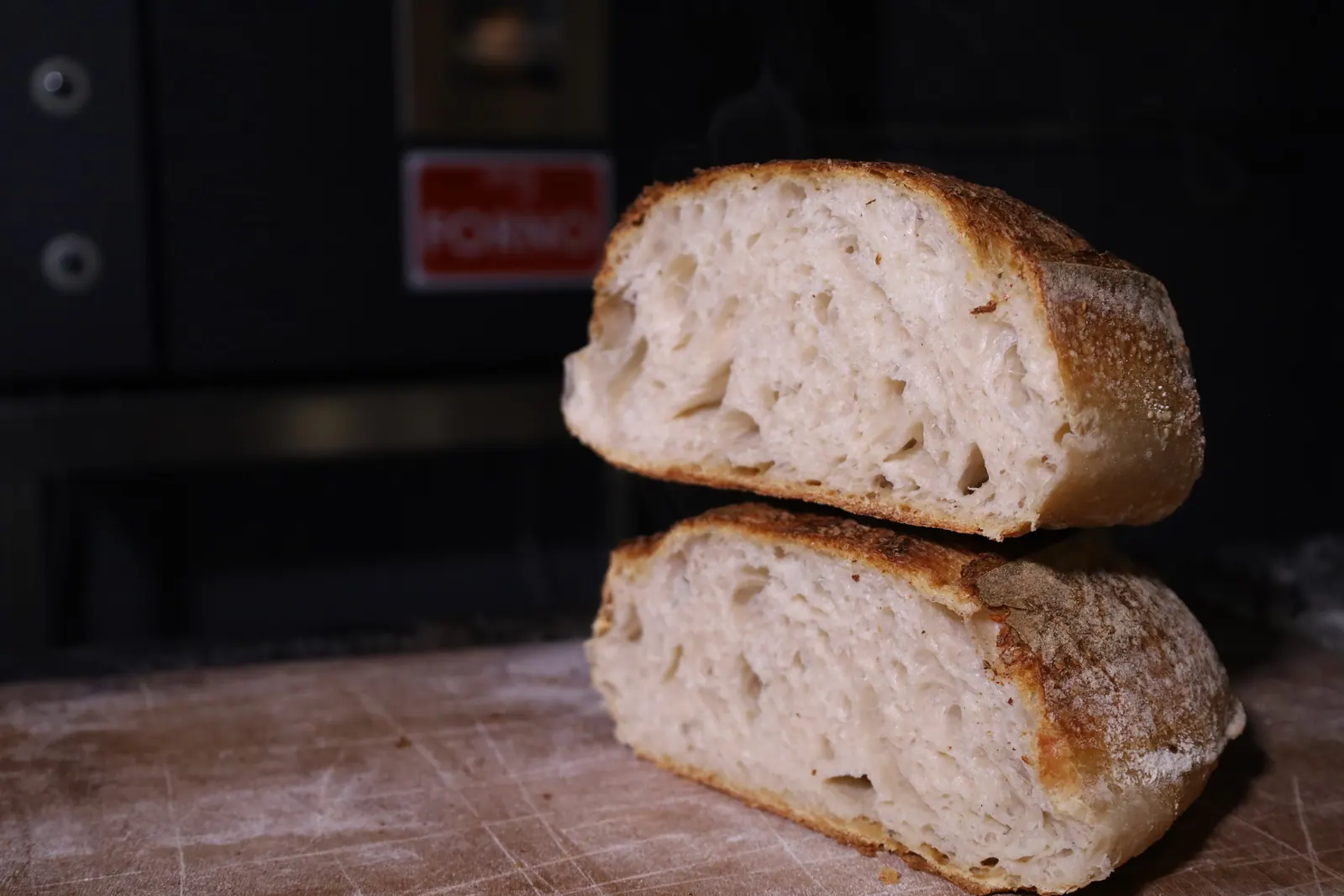 A sourdough loaf cut in half, its open crumb facing you