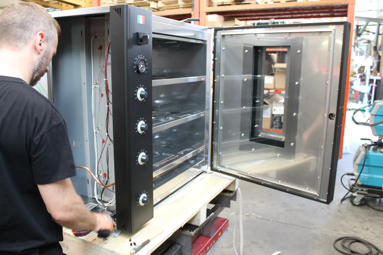 A worker building a MyForno oven by hand in the factory near Verona.