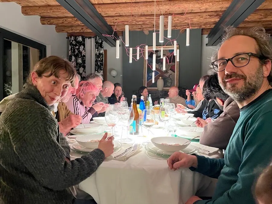 Bakers around a long dinner table under a beamed ceiling