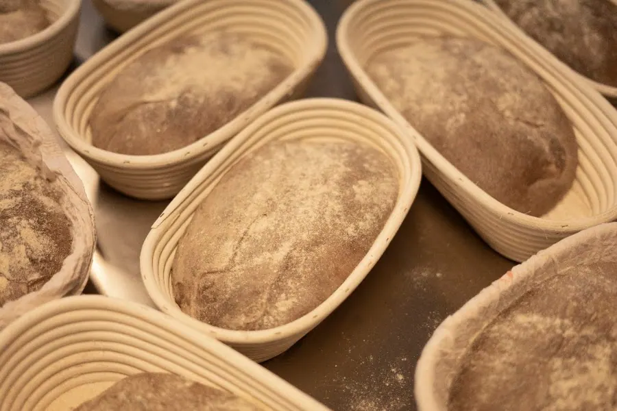 Floured dough resting in oval wicker proving baskets