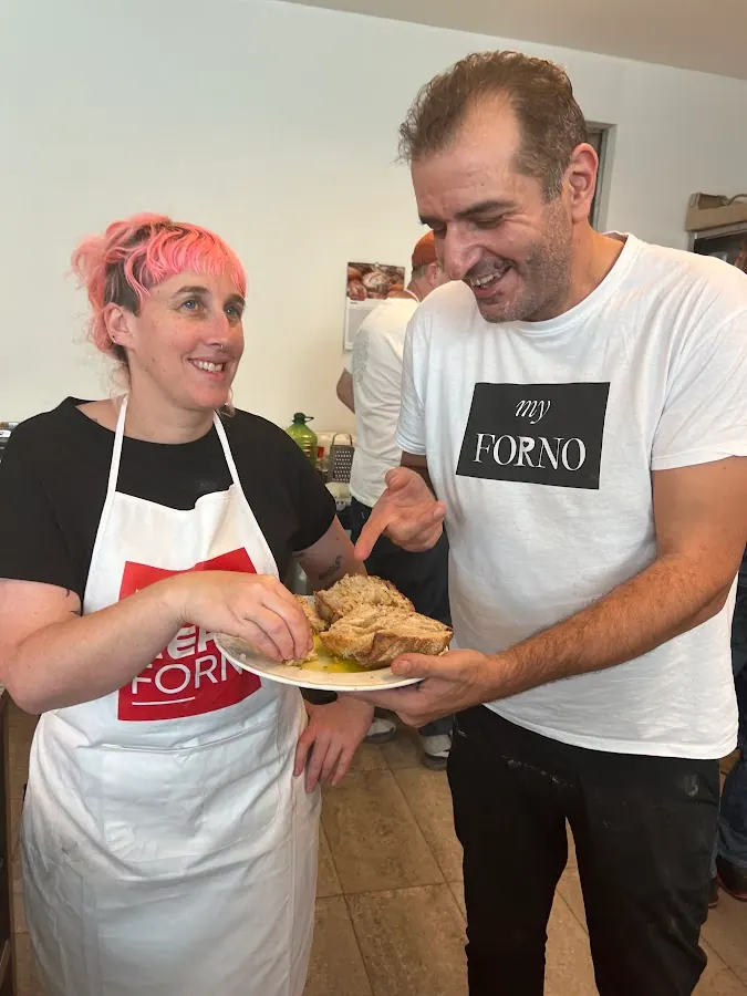 Two bakers sharing a plate of sliced bread
