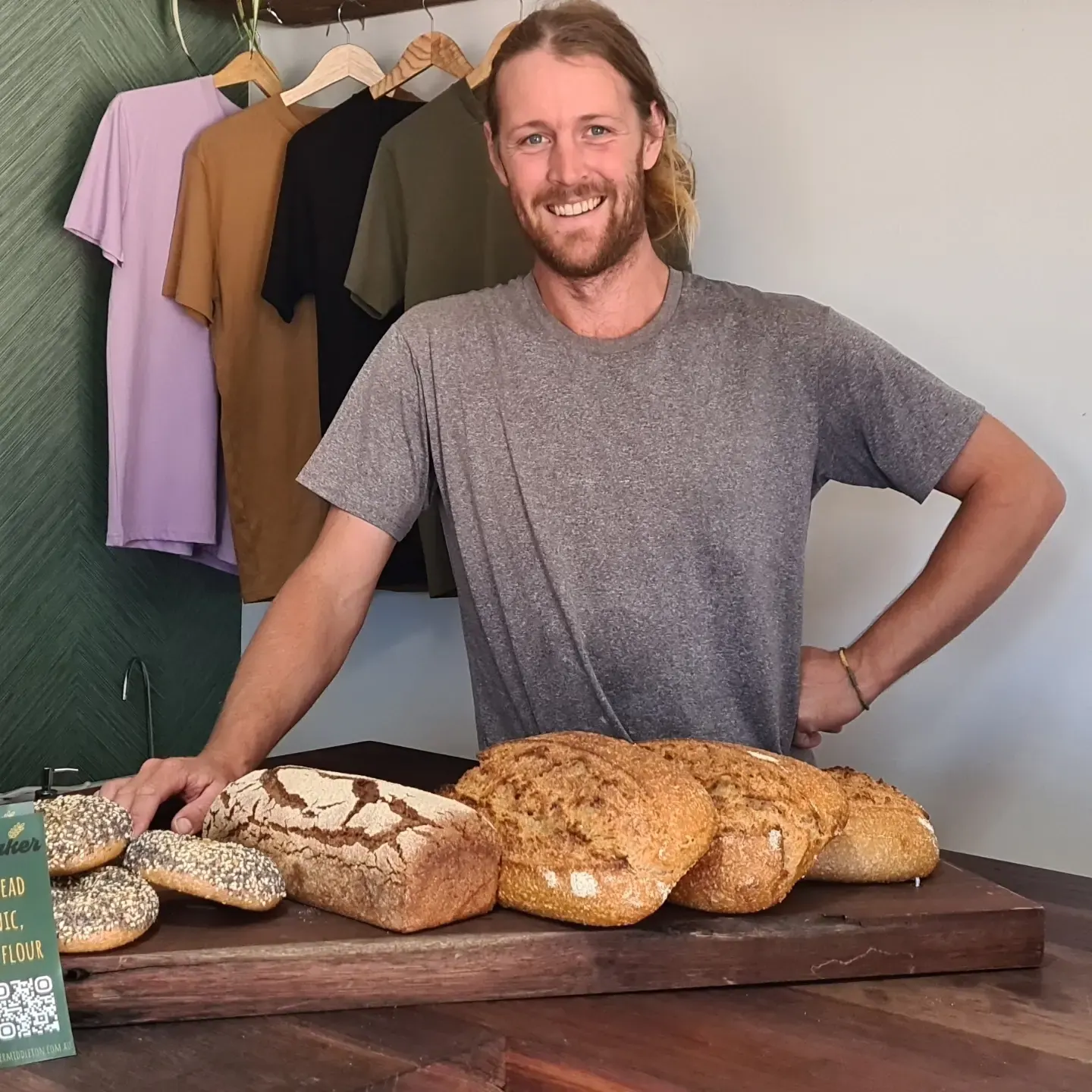 A Hey Baker baker with a board of sourdough loaves